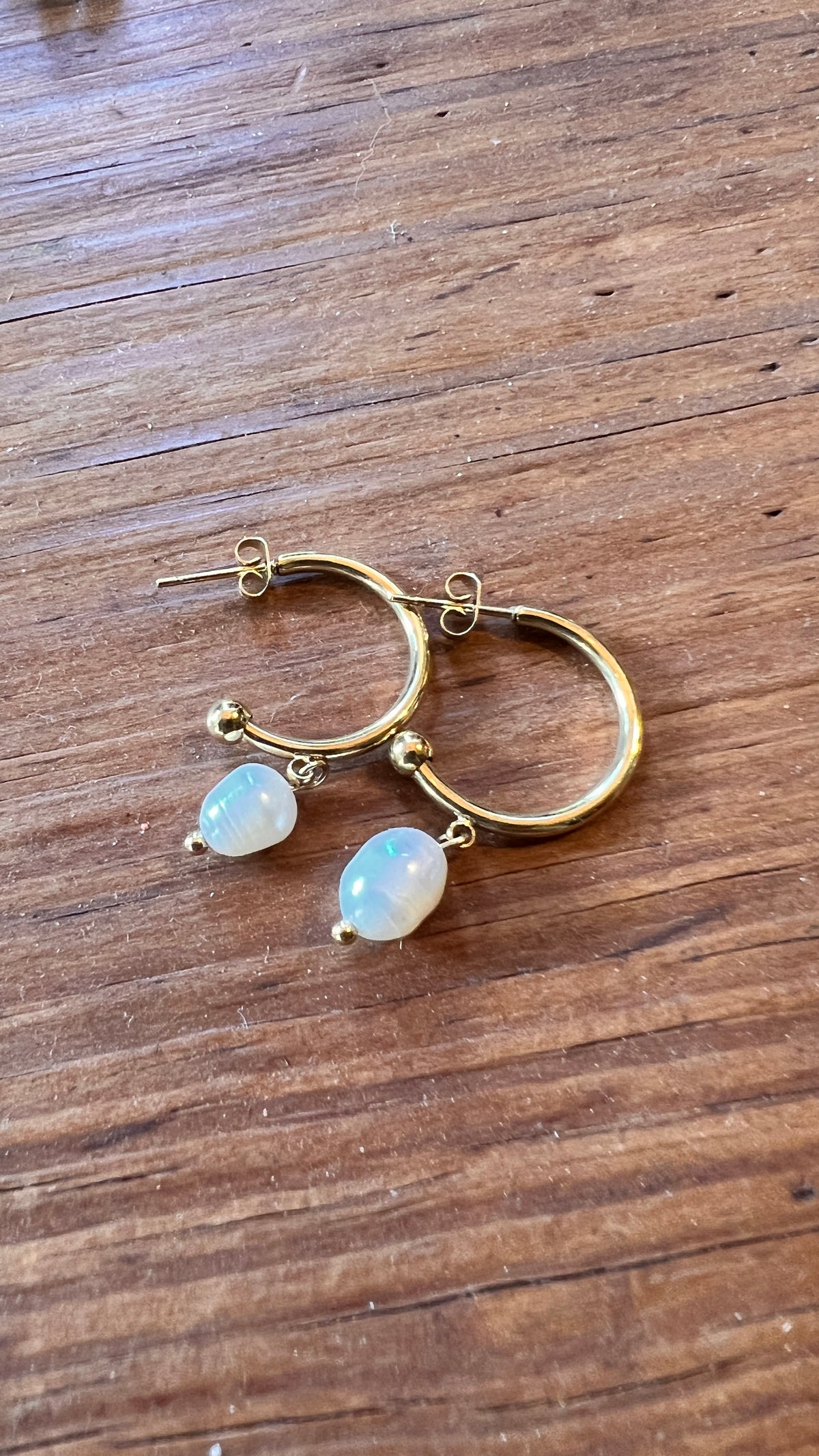 Gold earrings combined with a pearl