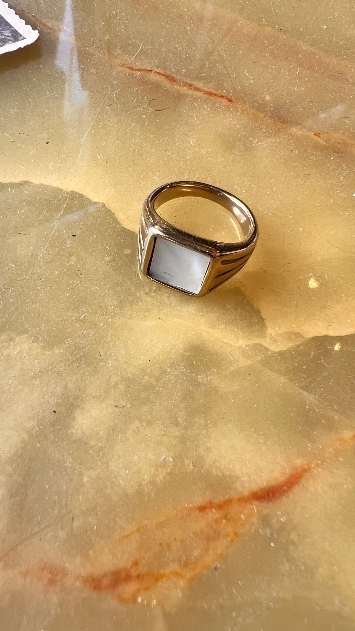 A gold-plated ring with a white stone