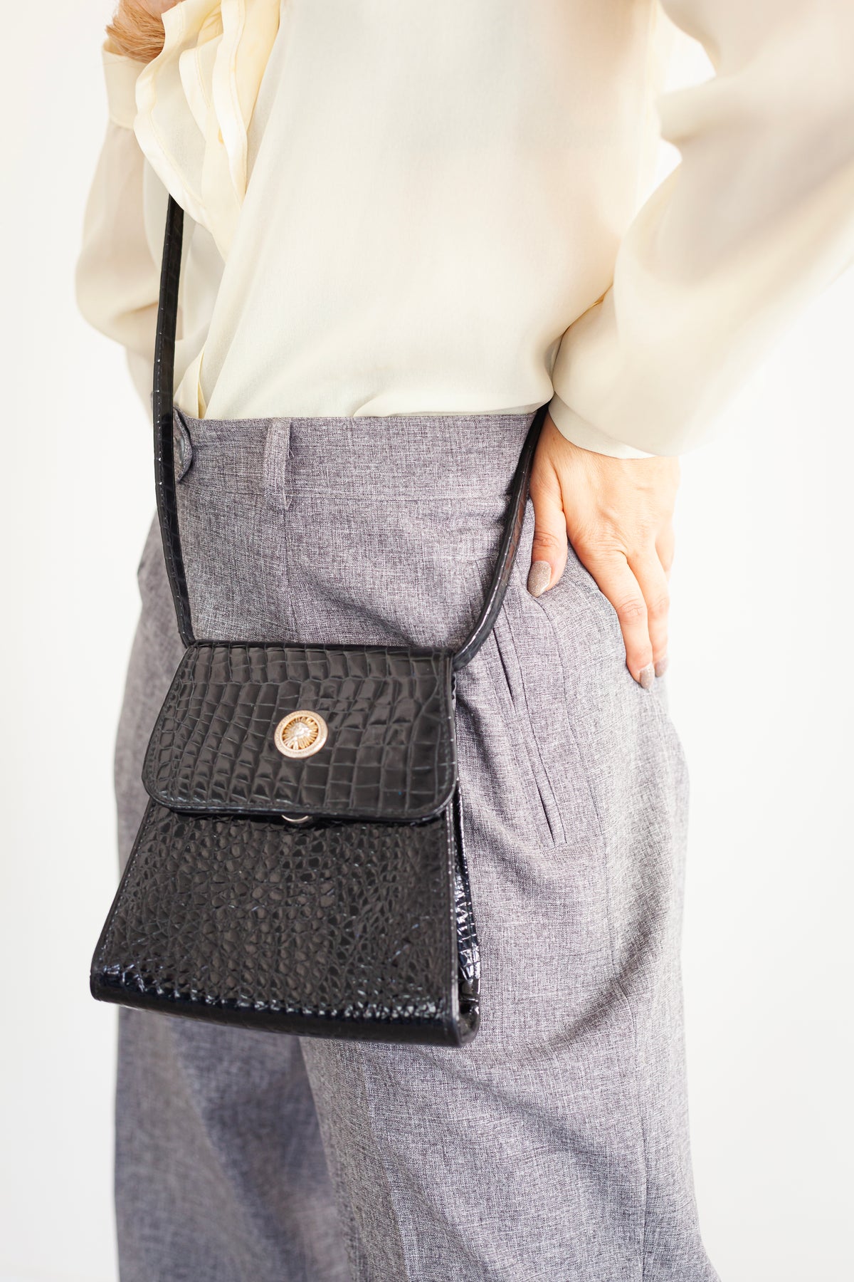 A small evening bag made of lacquer with a long strap