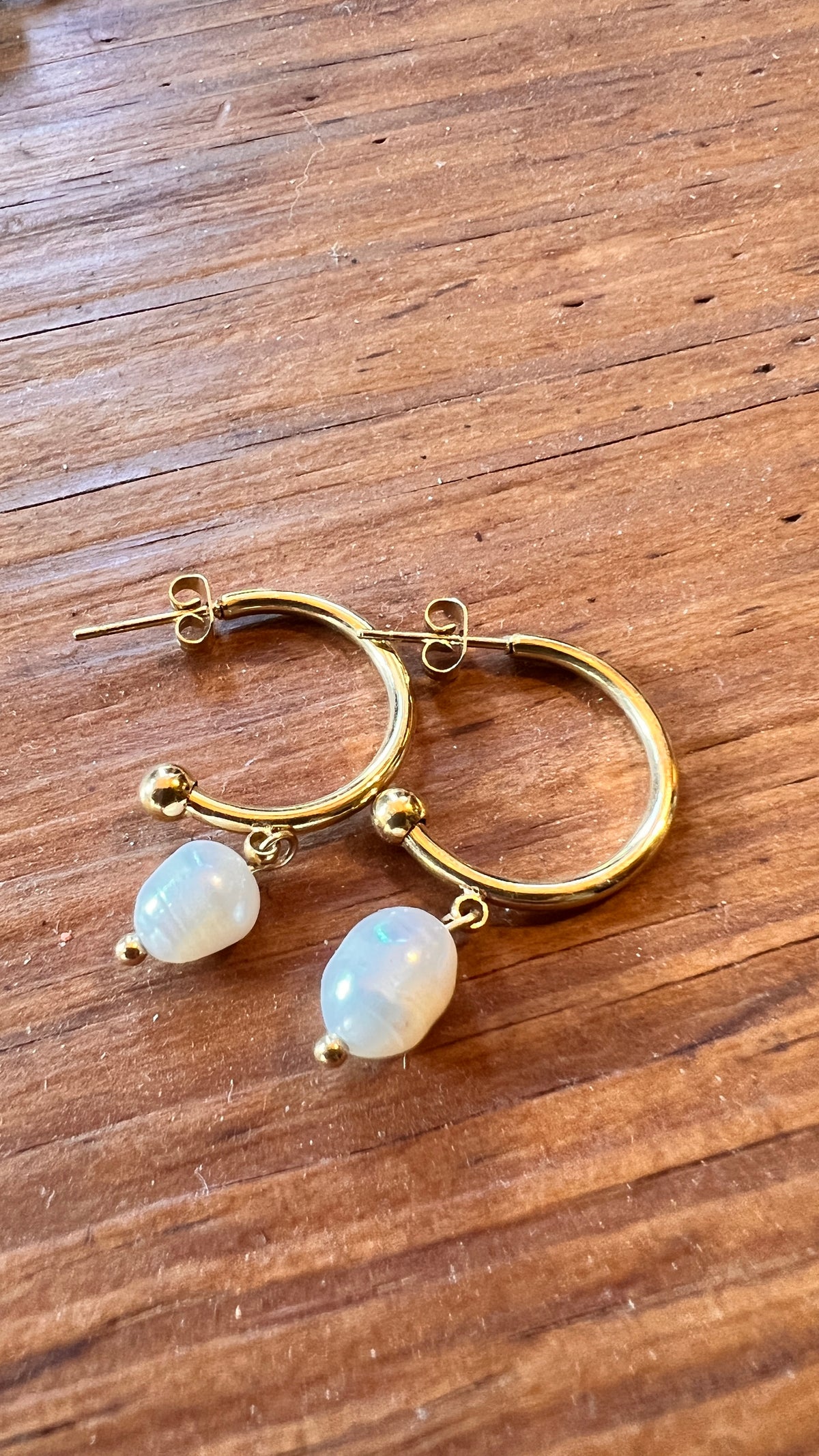 Gold earrings combined with a pearl