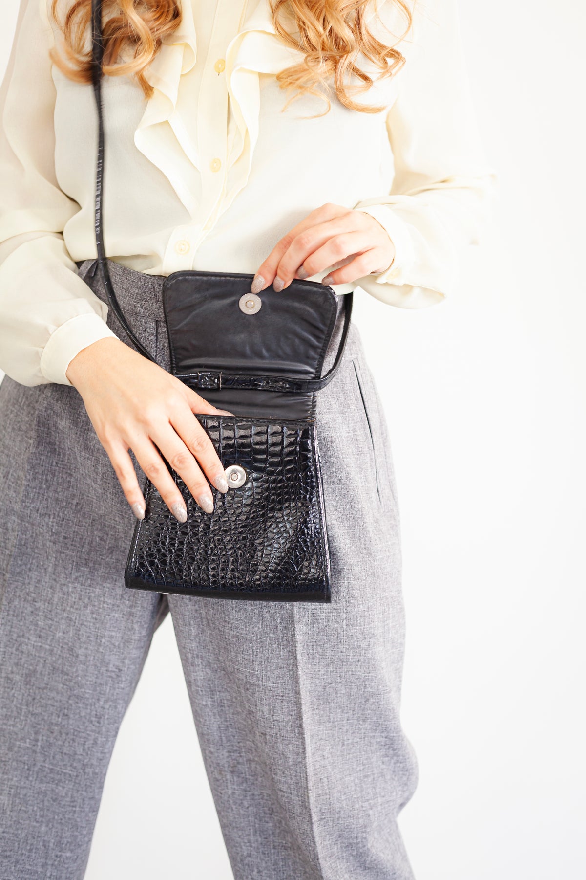 A small evening bag made of lacquer with a long strap