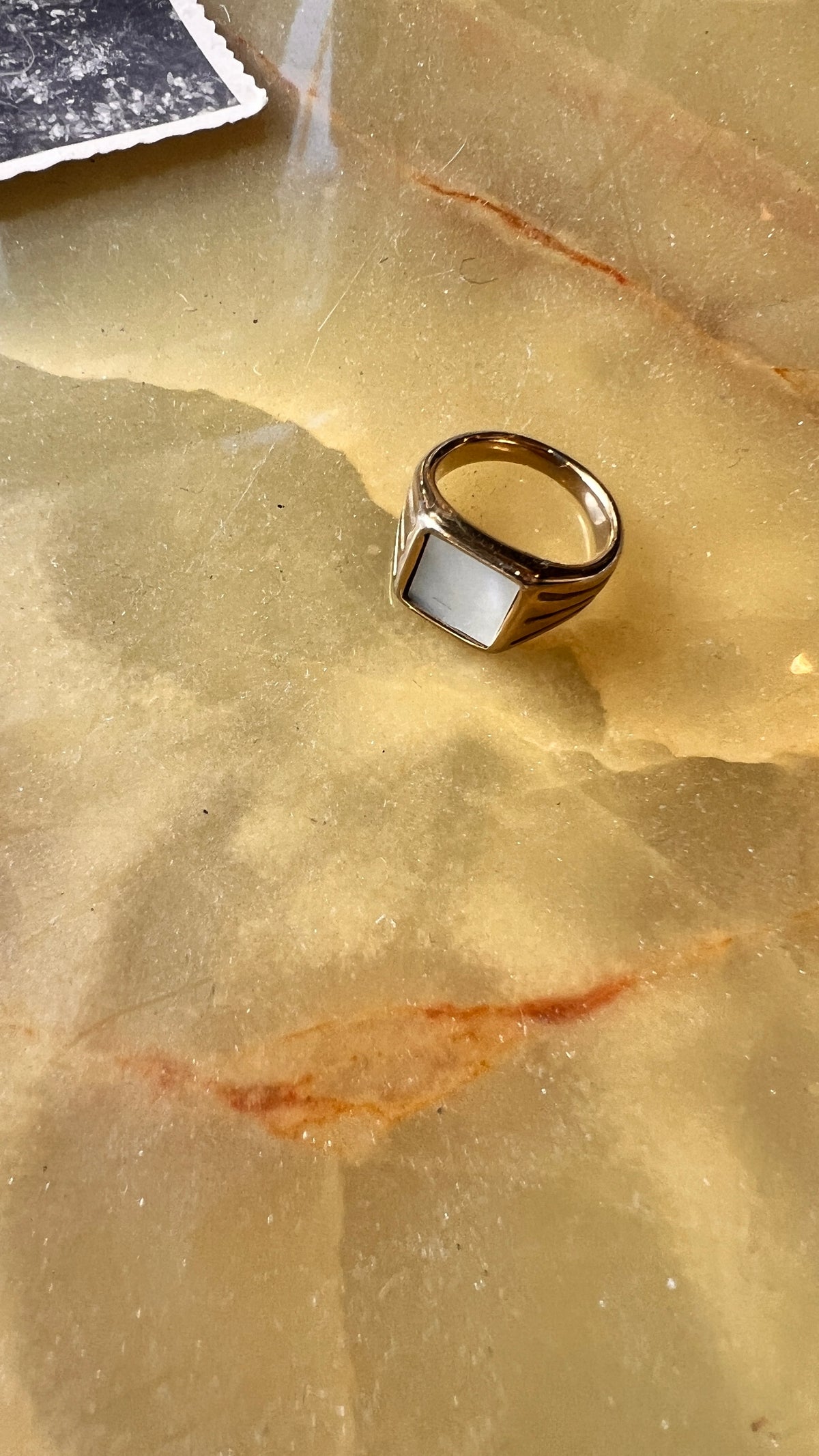 A gold-plated ring with a white stone