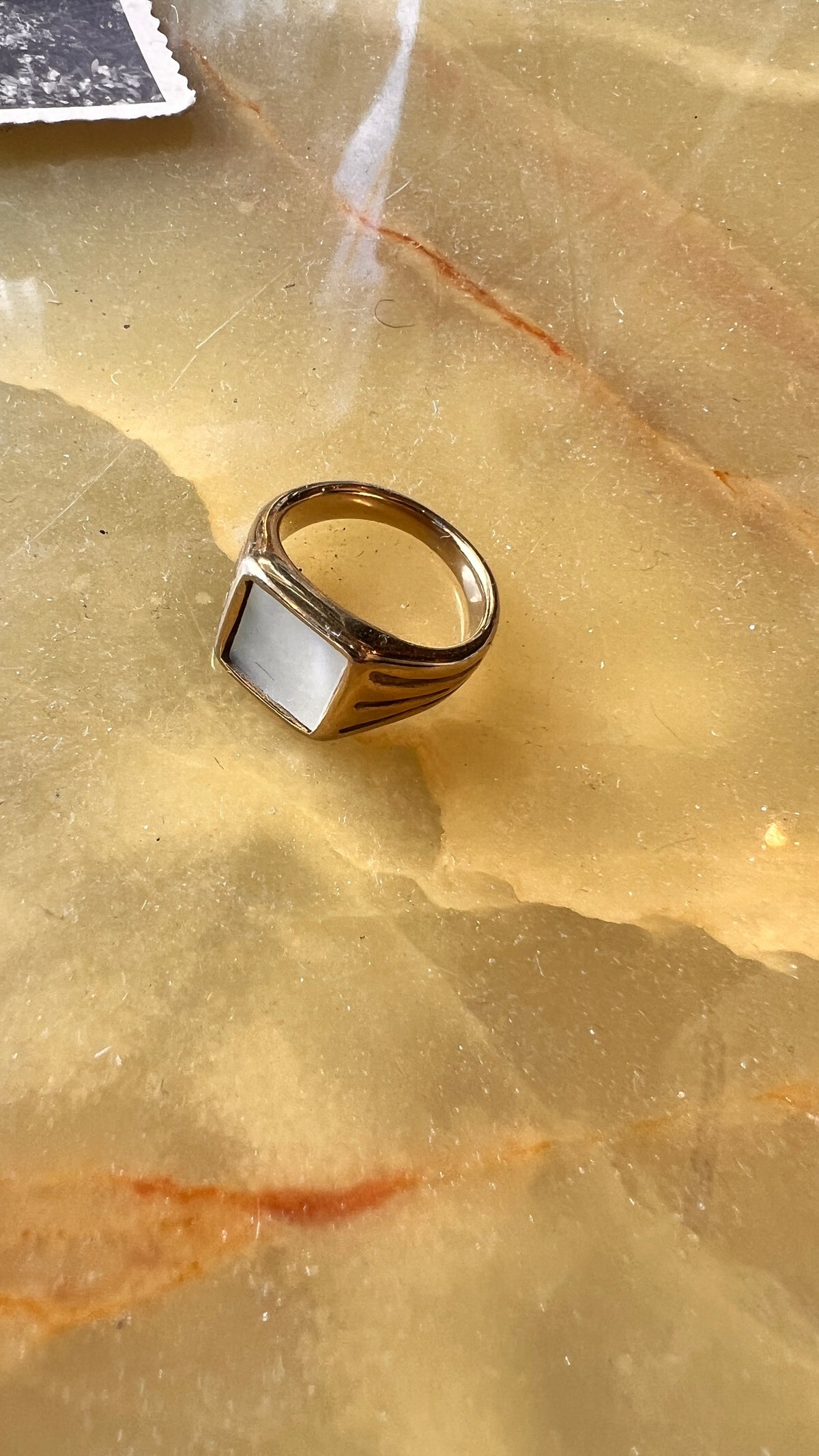 A gold-plated ring with a white stone
