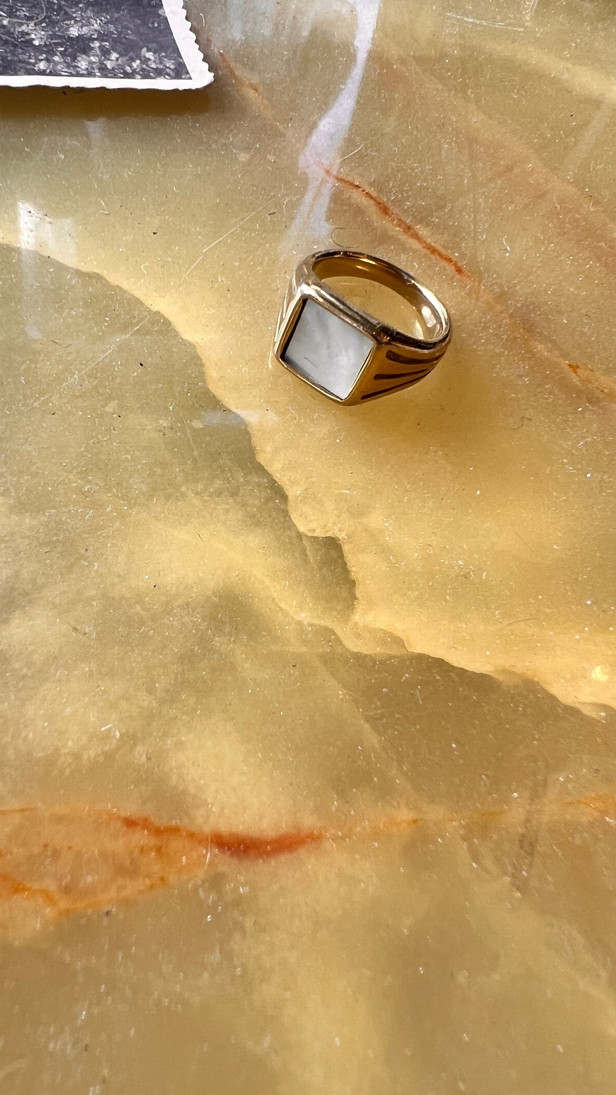A gold-plated ring with a white stone