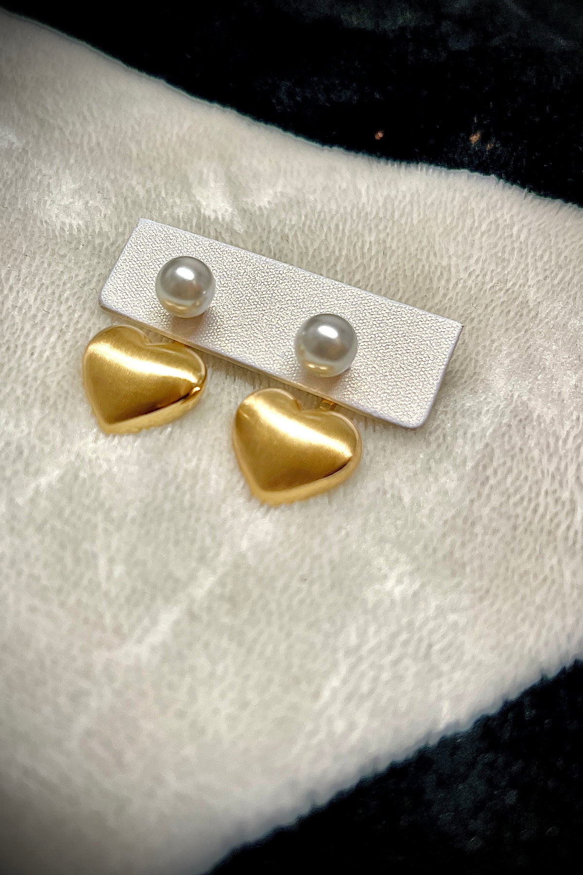 Gold heart earrings combined with a pearl