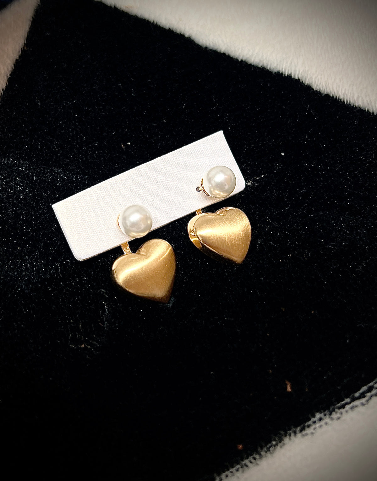 Gold heart earrings combined with a pearl