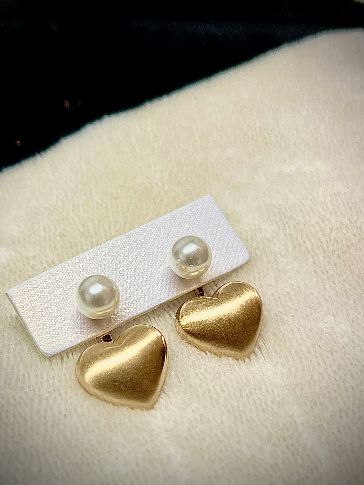 Gold heart earrings combined with a pearl